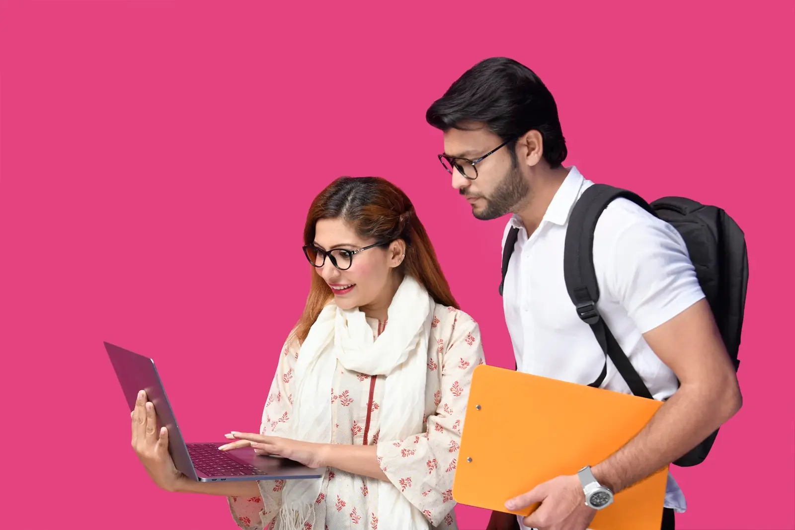 A young woman and a young man with a backpack looking at a laptop together, the man holding an orange clipboard, against a pink background